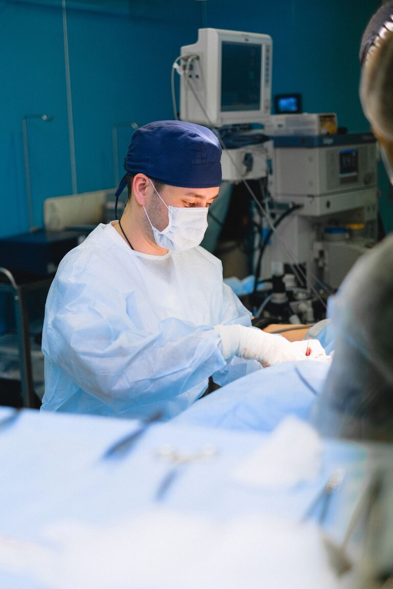 Medical professionals in an operating room performing surgery with advanced equipment.